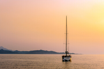France. Corsica. Cap Corse. Sailboat anchored in the Bay of Nonza at sunset