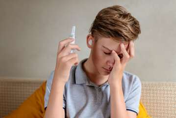 Teen boy suffering from strong earache or ear pain. Ear inflammation, otitis or tinnitus. Otitis...