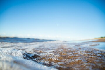 Closeup shot of foamy blue sea waves on a seashore