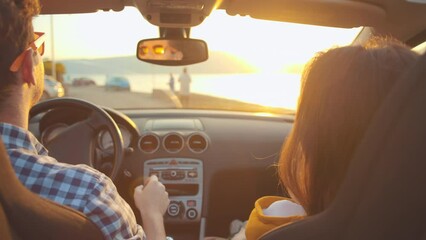 Happy people travel in cabriolet. Young family of mother, father driver and a baby in car driving to adventure at golden sunset. Child and parents spend time together. Togetherness and love concept