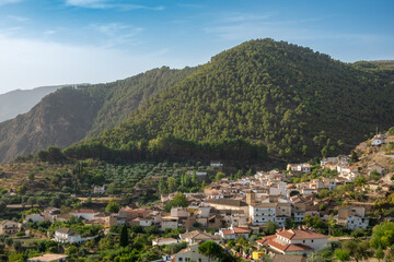 Fototapeta na wymiar View of the Granada town of Cónchar (Spain) between mountains in the Lecrín Valley, a sunny autumn morning