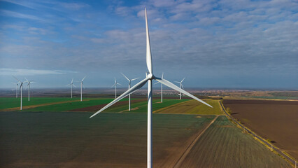 Wind turbines standing in the field from the drone point of view