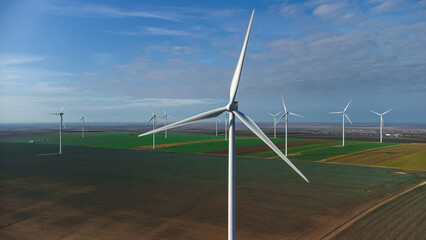 Wind turbines standing in the field from the drone point of view