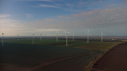 Wind turbines standing in the field from the drone point of view