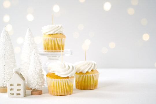 Christmas cupcake toppers mockup, styled with white reindeer and mini trees, bokeh party fairy lights on a minimalist white background.