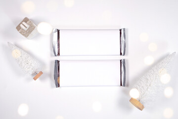 Christmas chocolate bar wrapper mockup, styled with white reindeer and mini trees, bokeh party...
