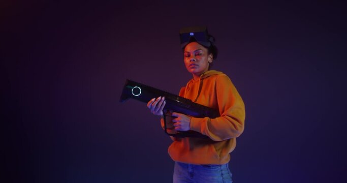 Woman in virtual reality headset holding a blaster in VR studio