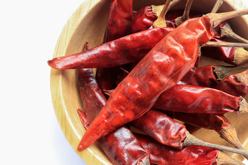Dried red hot chili pepper in wooden bowl isolated on white background