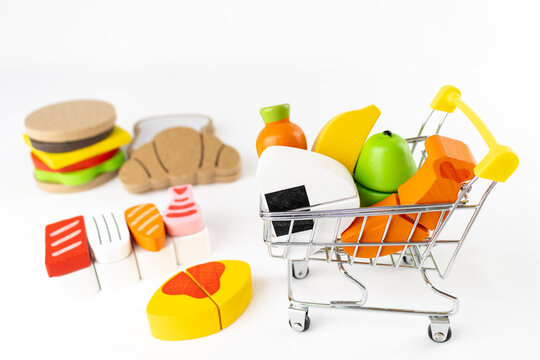 ショッピングカートと木製玩具の食べ物。買い物のイメージ