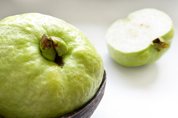 Close up of Fresh guava fruit in wooden bowl on the table.