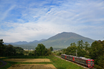 黒姫山の麓を走るしなの鉄道のローカル列車