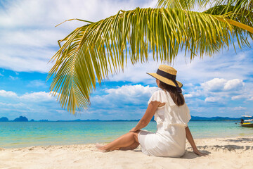 Woman under palm leaf