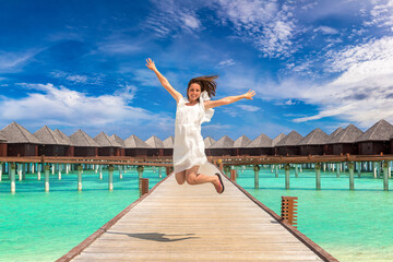 Woman jumping on the wooden pier