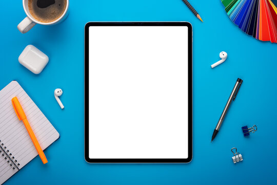 Notebook and Tablet Computer on Blue Desk or background laying flat on Creative workplace as mockup or Template with empty or blank page or screen