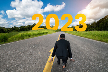 The 2023 New Year journey and future vision concept . Businessman traveling on highway road leading...