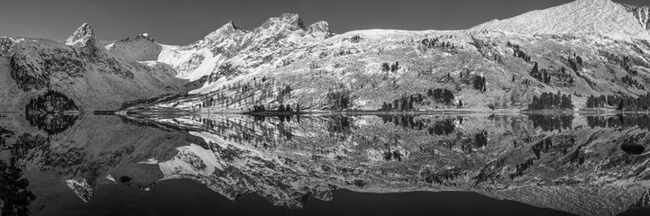 Fototapeta na wymiar Picturesque reflection of snow-capped mountains in the lake, black and white landscape, panoramic view
