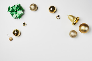 christmas decorations on a white background with green bow and gold ornaments scattereded around...
