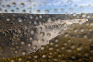 Dettifoss waterfall Iceland with droplets of water on camera lens with strong wind blowing the...