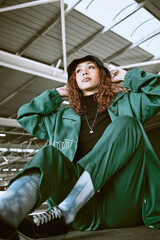 Fashion, green designer clothes and black woman relax on floor with gen z streetwear, hip hop style...