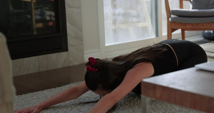 Pregnant woman in second trimester does at home yoga through online course