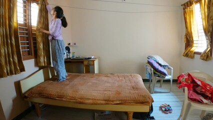 4K timelapse of Indian girl cleaning her house during morning.  cleaning housework and housekeeping concept. Process of cleaning the house. Female cleaned up the mess in the room.