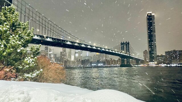 Manhattan Bridge under snow storm at night - New York City at night view in Winter from Brooklyn - concept of weather, winter, america, - Powered by Adobe