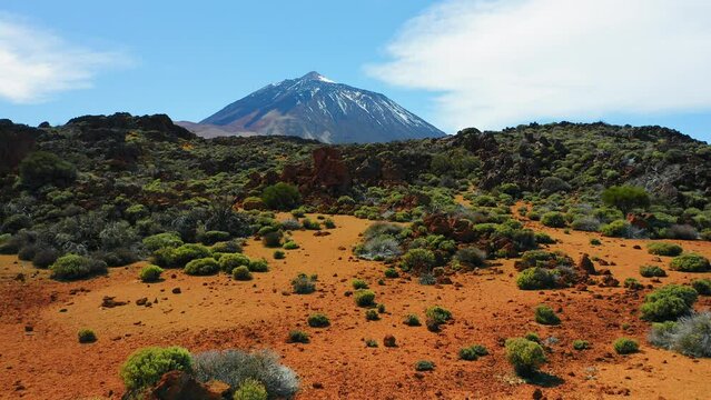 Volcanic nature, mountain landscape. Aerial fly to the Mount Teide volcano in Tenerife, Canaries, Spain. Sunny afternoon. Snowy peak.
