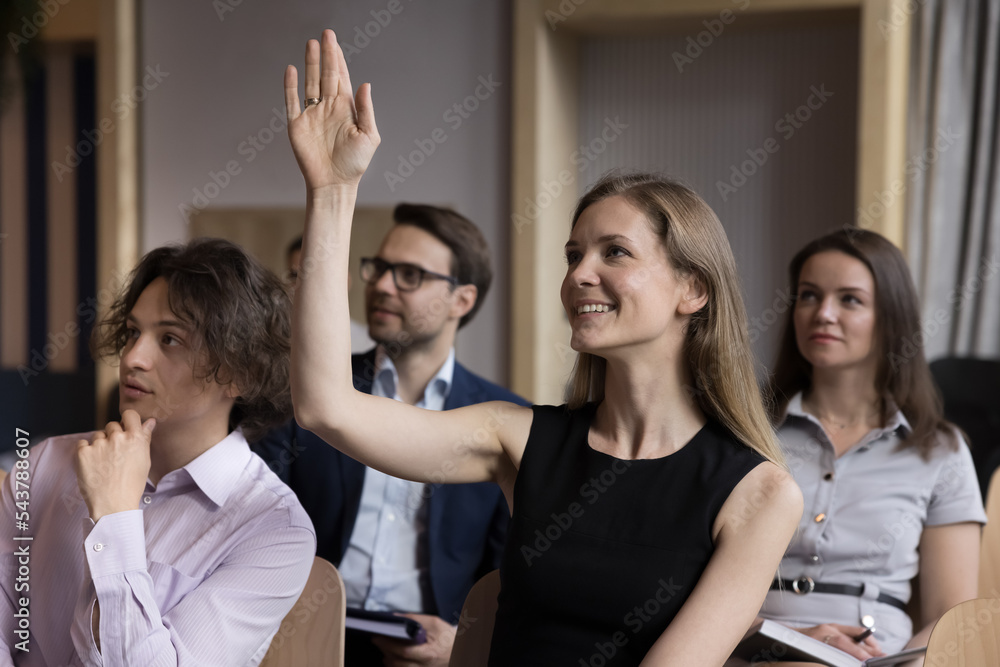 Sticker Smiling woman employee, educational seminar participant raise arm to ask question engaged in teambuilding activity during meeting or briefing in conference hall. Interview or workshop, opinion, vote