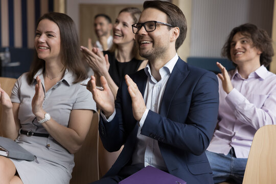 Happy audience applauding to presenter, thanking for good speech finish workshop or training gathered in conference hall. Employees clap hands express recognition to coach accomplish business seminar