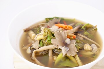 Mushroom curry , Mushroom soup in Thai called GangHed all many mushroom and green vegetables isolated on white background.Termite Mushroom soup