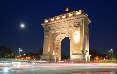 Arch of Triumph in Bucharest. Night landscape under the full moon with this iconic landmark from Romania. Long exposure photo.