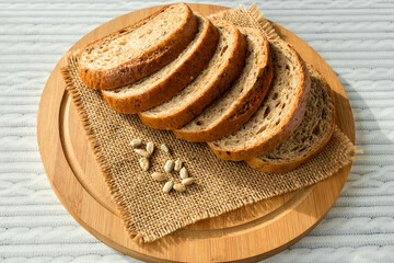 Sliced wheat-rye bread with sunflower seeds on a kitchen board.