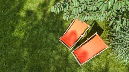Summer garden with sunbed deckchairs on grass aerial top view, green park trees and place for relax...