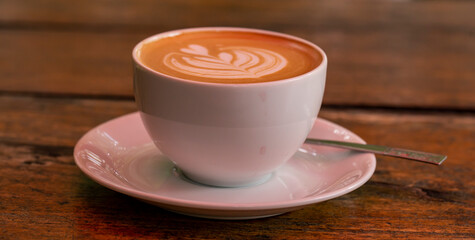 Close up photo of latte coffee on wooden table.