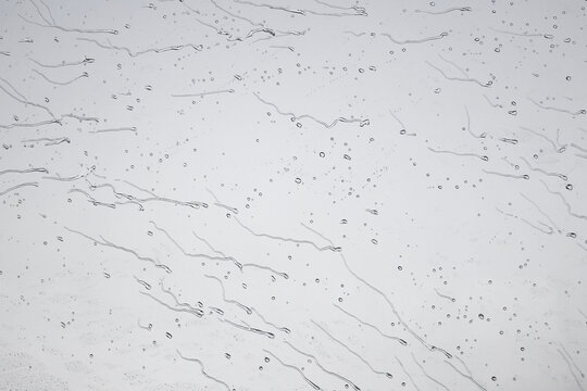 Gouttes de pluie contre une vitre pendant un orage avec un effet artistique et des &eacute;l&eacute;ments graphiques surprenant pour fond d'&eacute;cran