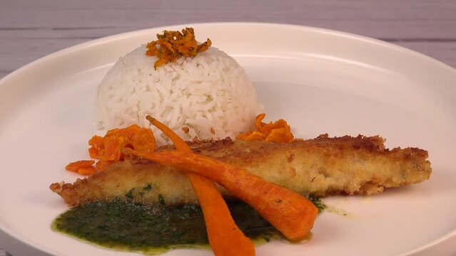 Recipe for Hake fillet breaded with panko, rice, carrot chips and coriander sauce. High quality photo
