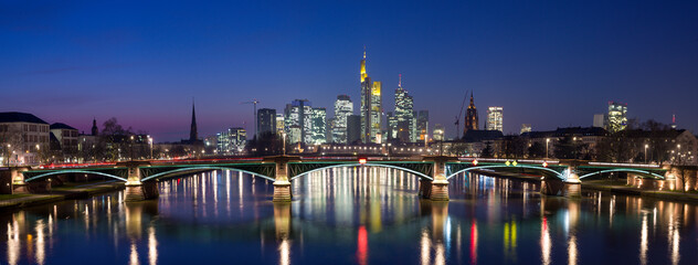 Panoramafoto der künstlich erleuchteten abendlichen Skyline von Frankfurt am Main mit Himmel und...
