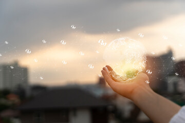 Hand showing business icons and globe at sunset. Global business network in hand on a blurred background.