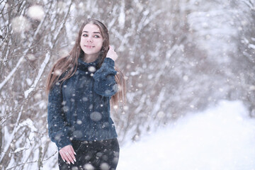 Girl in a winter park in snowfall