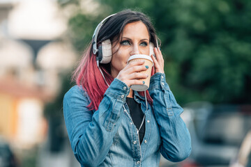 urban young woman with headphones and takeaway