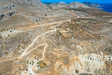 Spectacular aerial view with serpentine off-road track to top of Attavyros mountain. Highest mountain  in Rhodes island, Greece. Tourism and vacations concept.