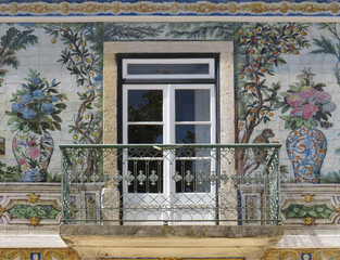 Streets of Lisbon. Traditional tiled facade decorated by tiles with colorful flowers, plants and...