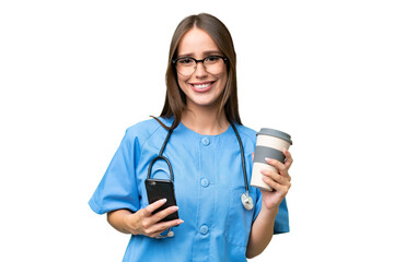 Young nurse caucasian woman over isolated background holding coffee to take away and a mobile