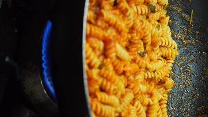 chef blending sauteing fusilli italian pasta with mushroom sauce at restaurant - Powered by Adobe