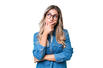 Young Uruguayan woman over isolated background having doubts and with confuse face expression - obrazy, fototapety, plakaty