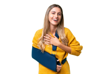 Young Uruguayan woman with broken arm and wearing a sling over isolated background smiling a lot