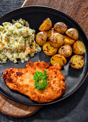 Chicken cutlet coated with breadcrumbs with potatoes and cabbage