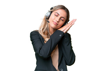 Telemarketer pretty Uruguayan woman working with a headset over isolated background making sleep gesture in dorable expression