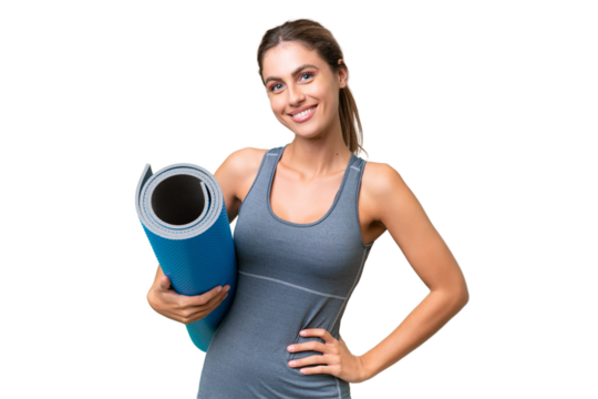 Pretty Young Uruguayan sport woman going to yoga classes while holding a mat over isolated background posing with arms at hip and smiling