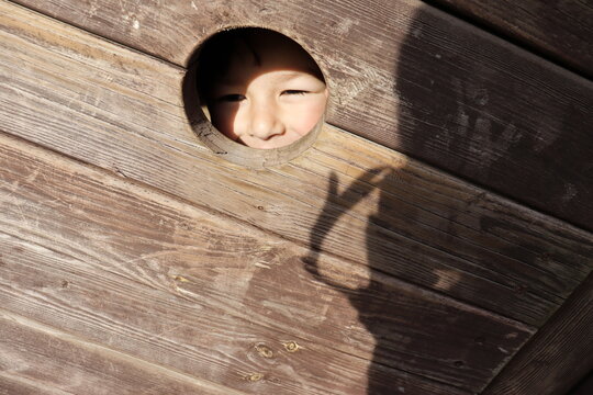 Boy's smiley face in a keyhole at the playground